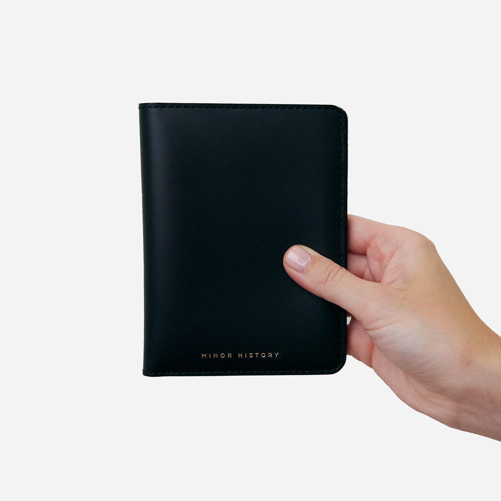 Atlas passport holder in black full-grain leather, side view highlighting slim profile