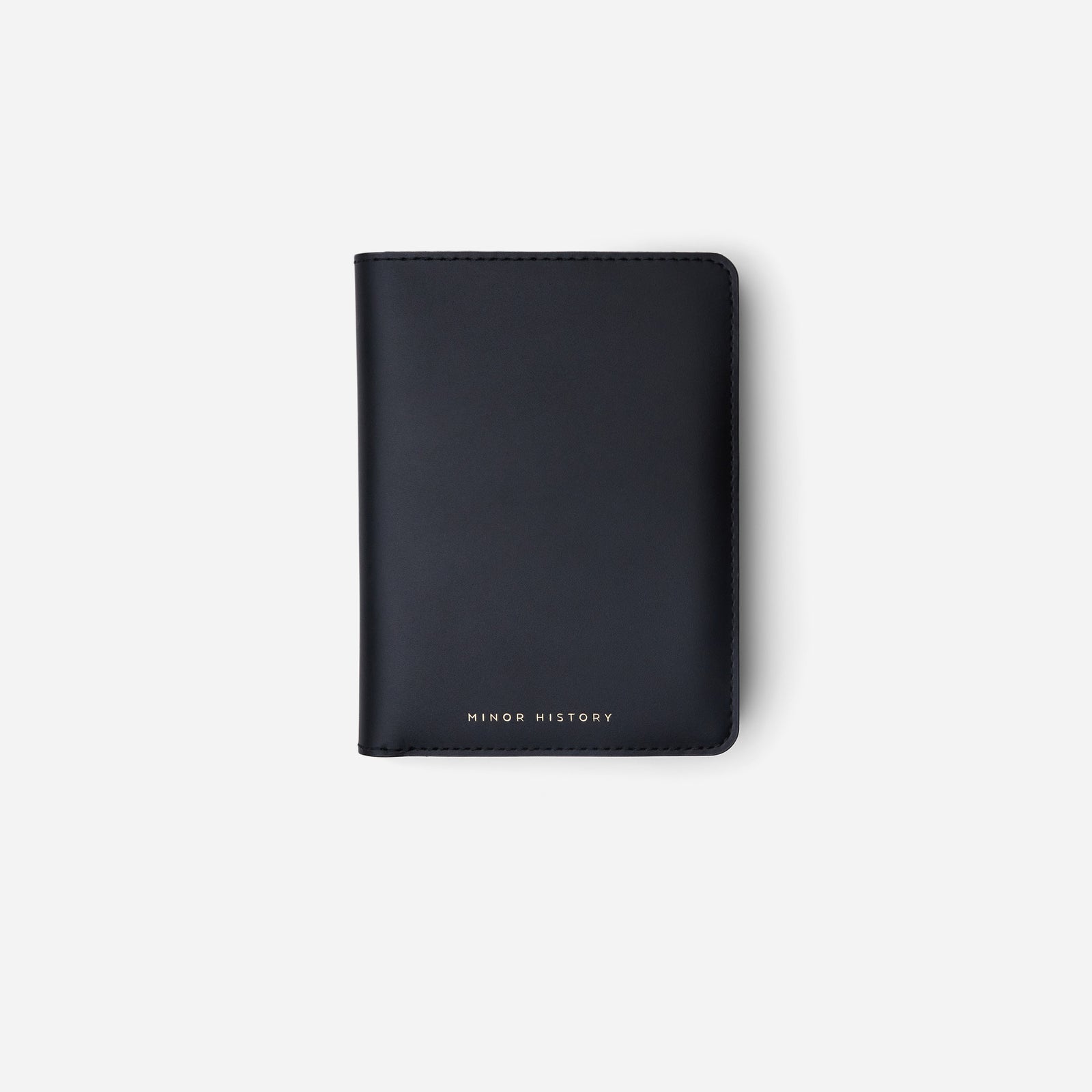 Atlas passport holder in black full-grain leather, side view highlighting slim profile