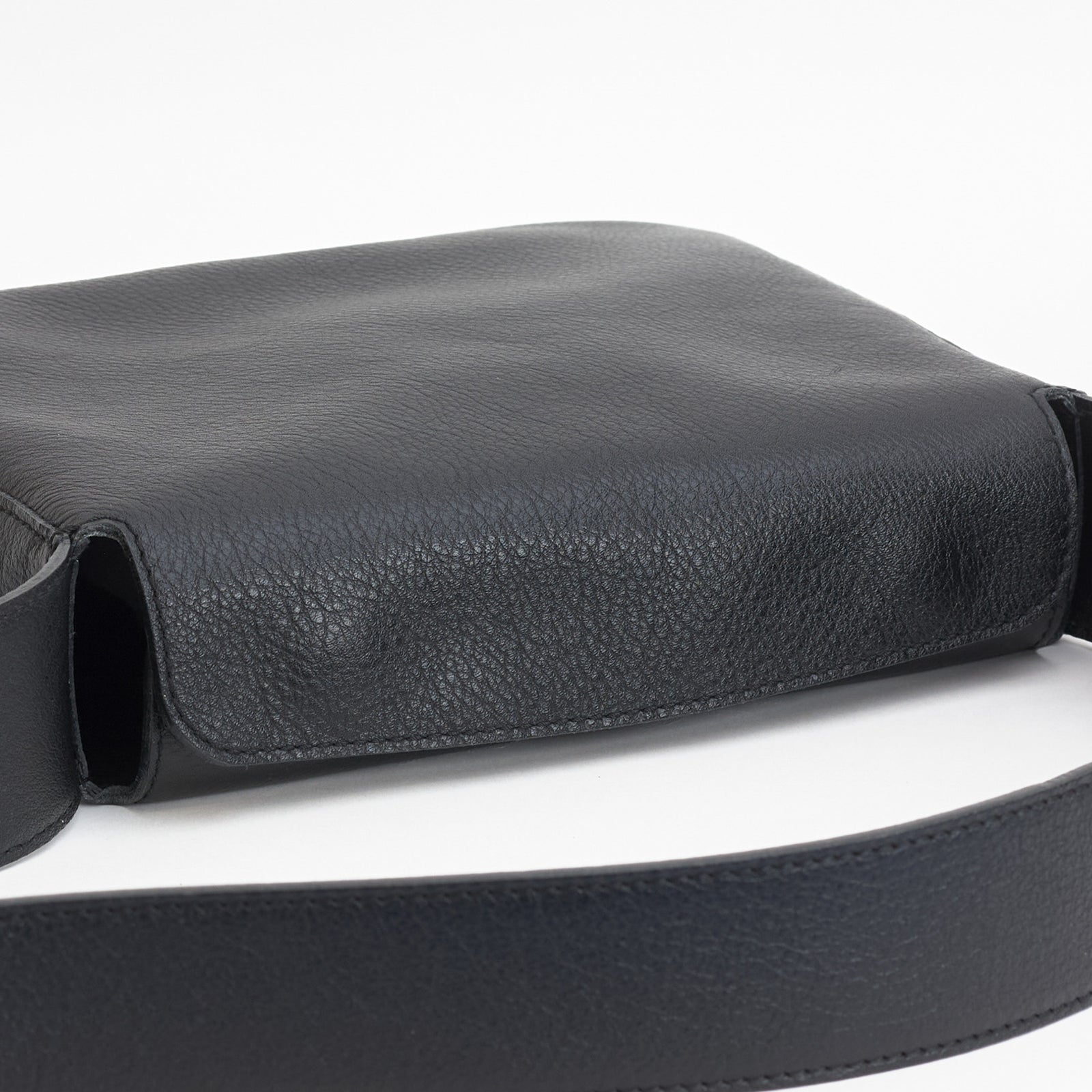 Little Frame crossbody bag in black full-grain leather, angled view highlighting its minimalist design, minimalist women's handbag