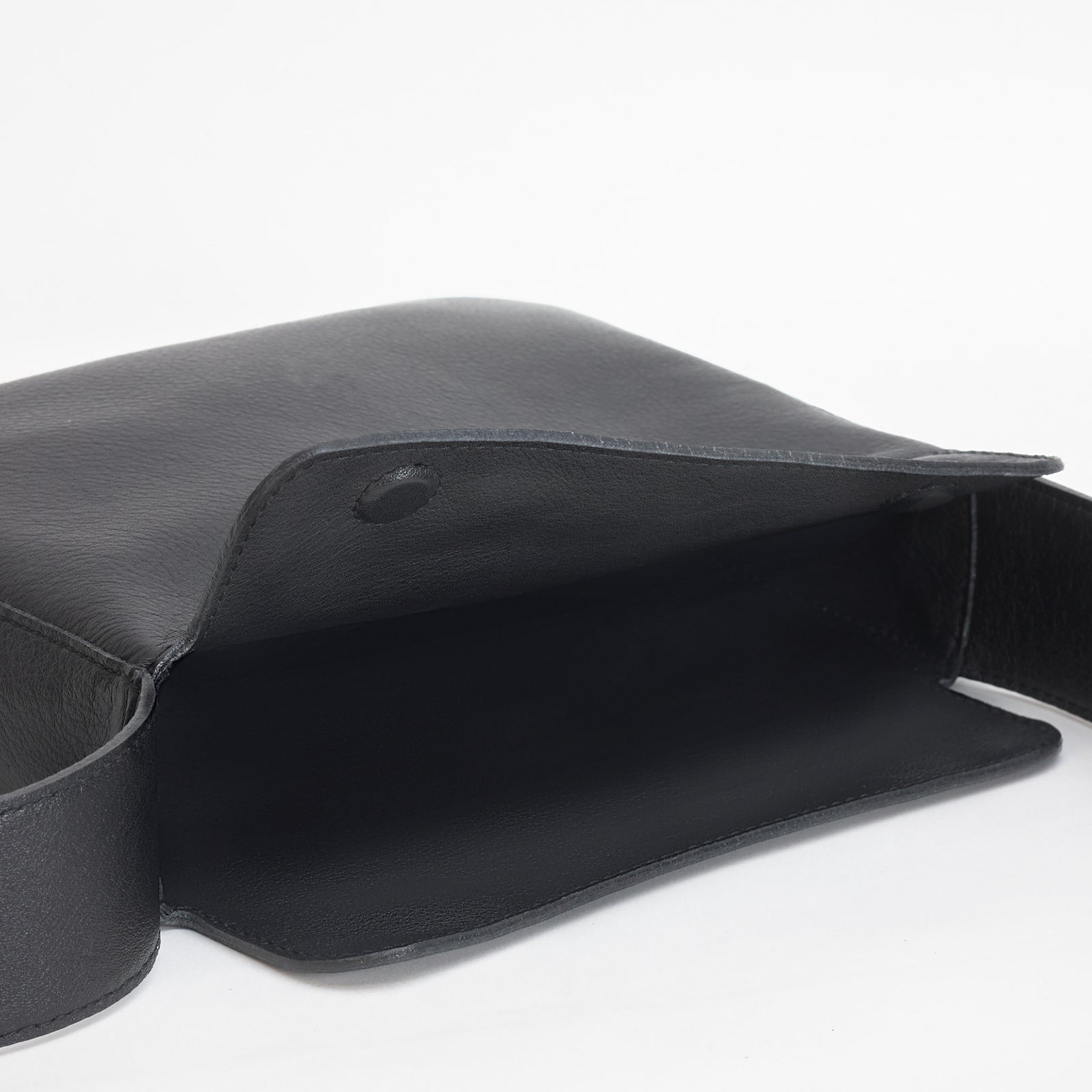 Little Frame crossbody bag in black full-grain leather, open view showing spacious double-lined interior, minimalist women's handbag