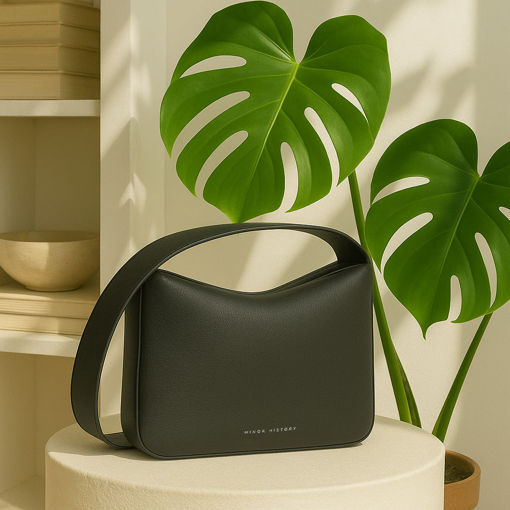 Black Leather Bag On Table With Plants