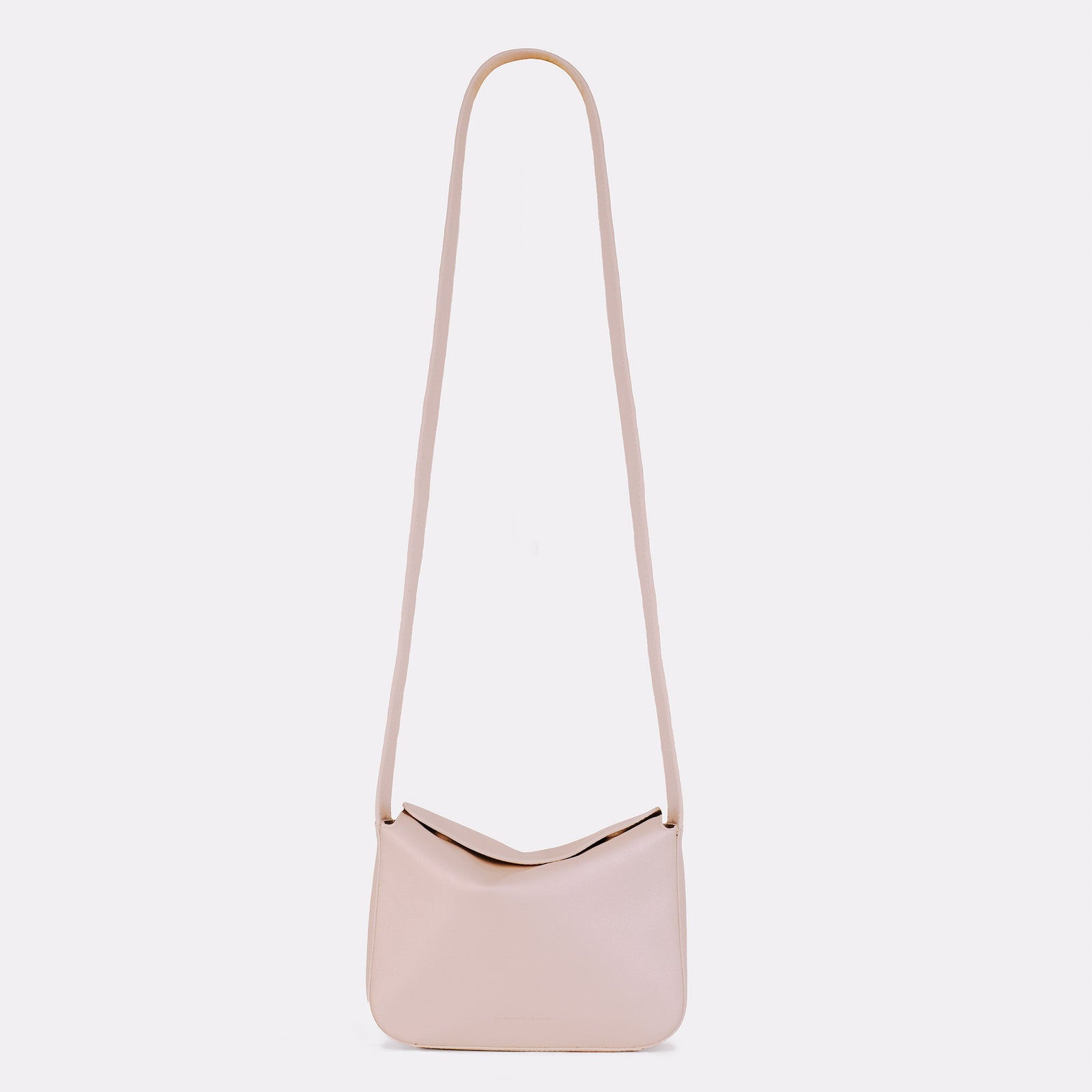 Little Frame crossbody bag in pearl full-grain leather, styled on tabletop with minimal props, minimalist women's handbag