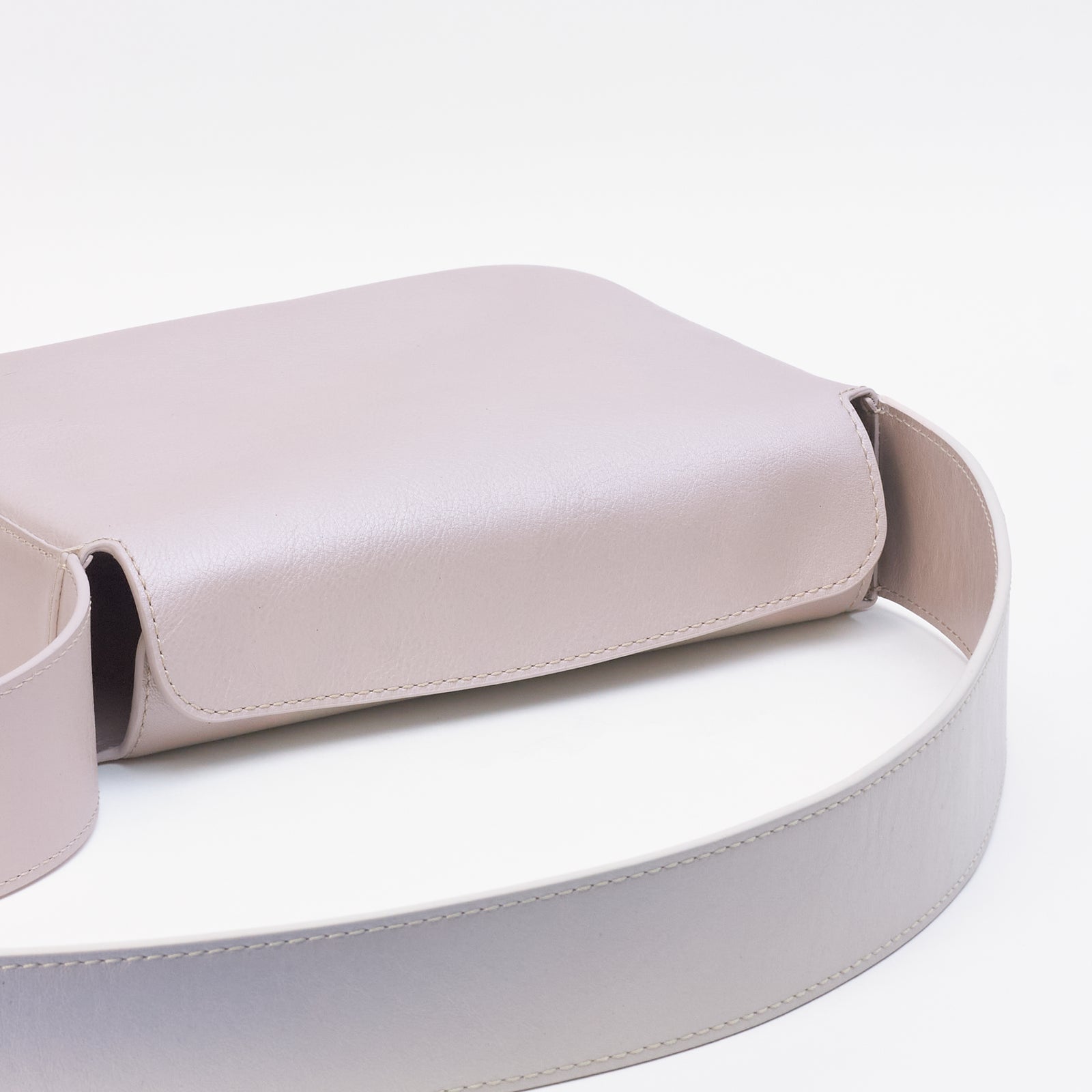 Little Frame crossbody bag in pearl full-grain leather, angled side view showing its clean lines and smooth texture, minimalist women's handbag