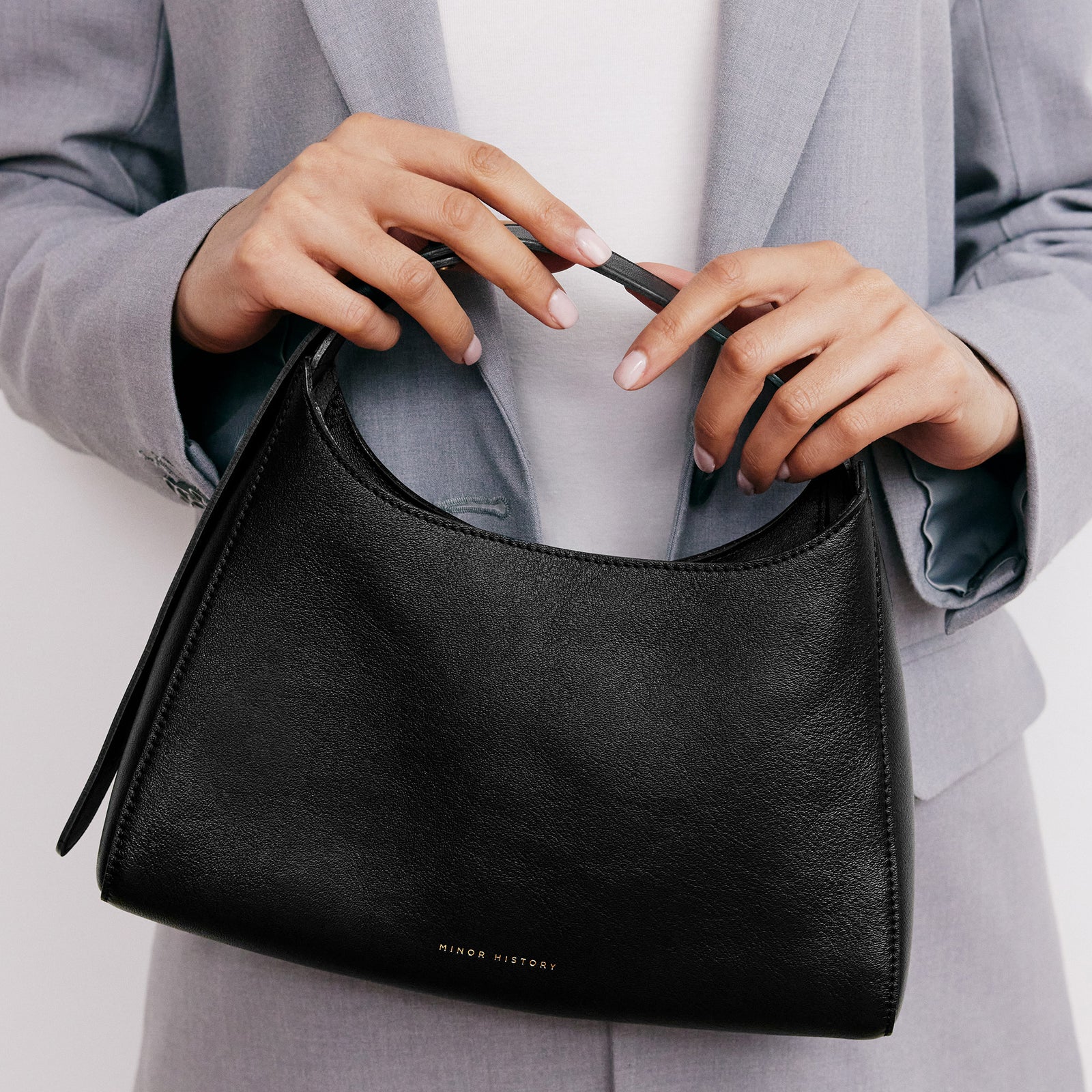 Overtime Tote Bag in black leather shown on minimalist background