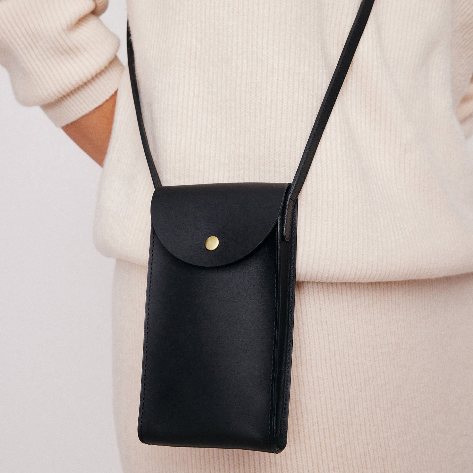 Mini Bandit crossbody bag in black full-grain leather, cropped view highlighting texture and stitching