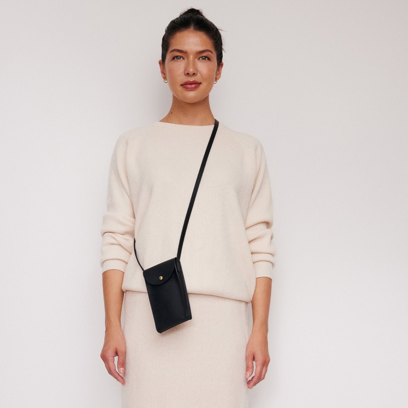 Mini Bandit crossbody bag in black full-grain leather, open view showing interior and compartments