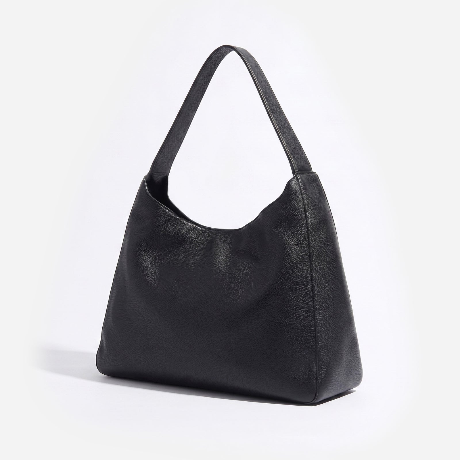 A black pebbled leather hobo shoulder bag with a single strap, photographed on a clean white background. -Black
