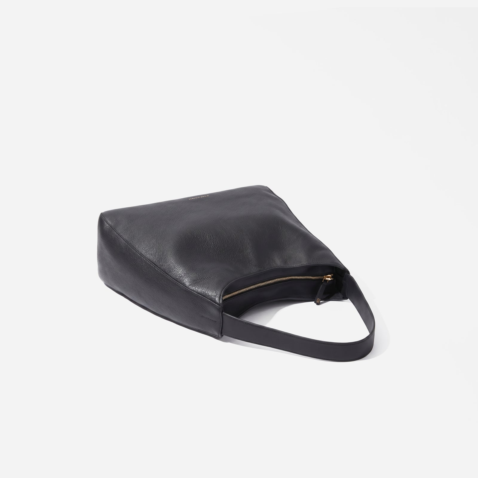 Black leather handbag on a light gray background. -Black