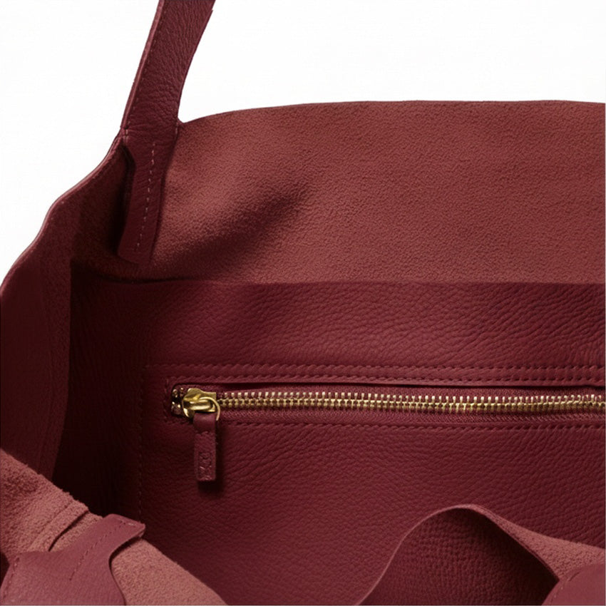 Close-up of a maroon handbag with a gold zipper on a white background - Cherry Cola