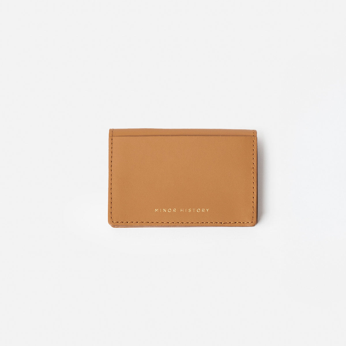 Brown leather cardholder with 'Minor History' branding on a white -background - Saddle