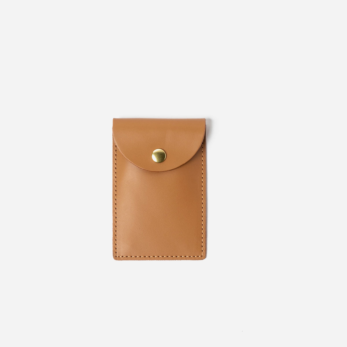 Tan leather cardholder with a gold button on a white background - saddle