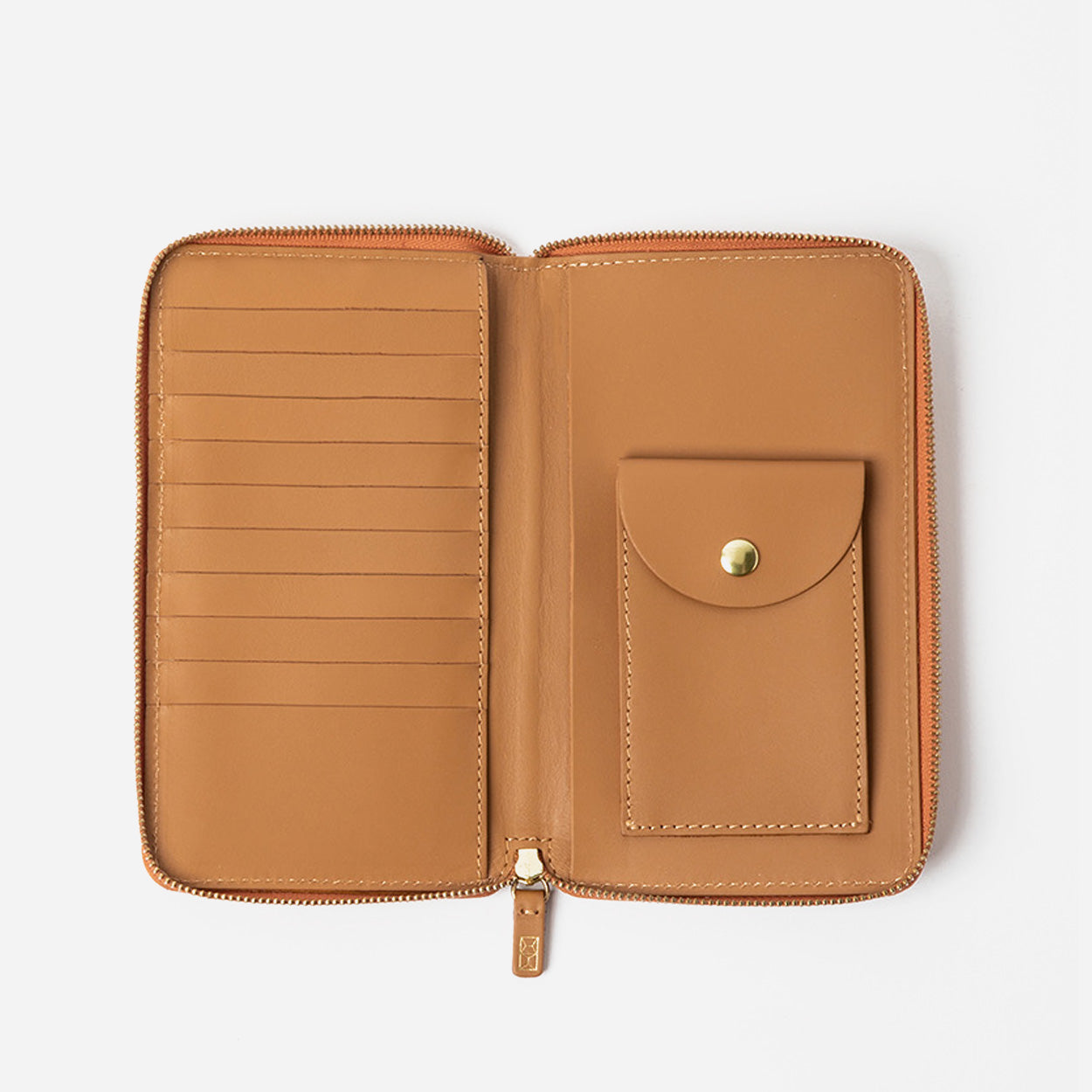 Open tan leather wallet with a card pocket on a light gray background - Saddle