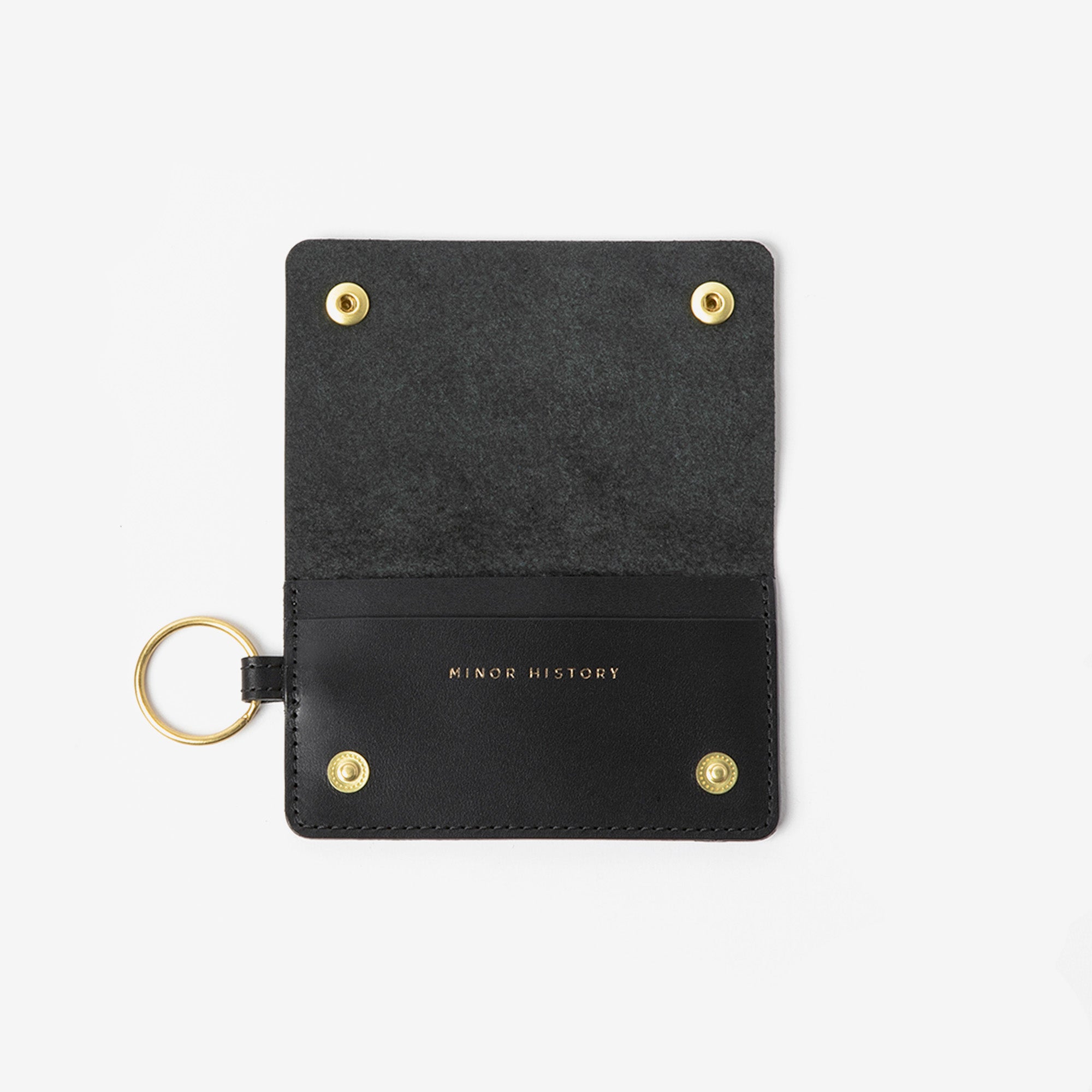 Black keychain cardholder with gold accents on a white background - Black