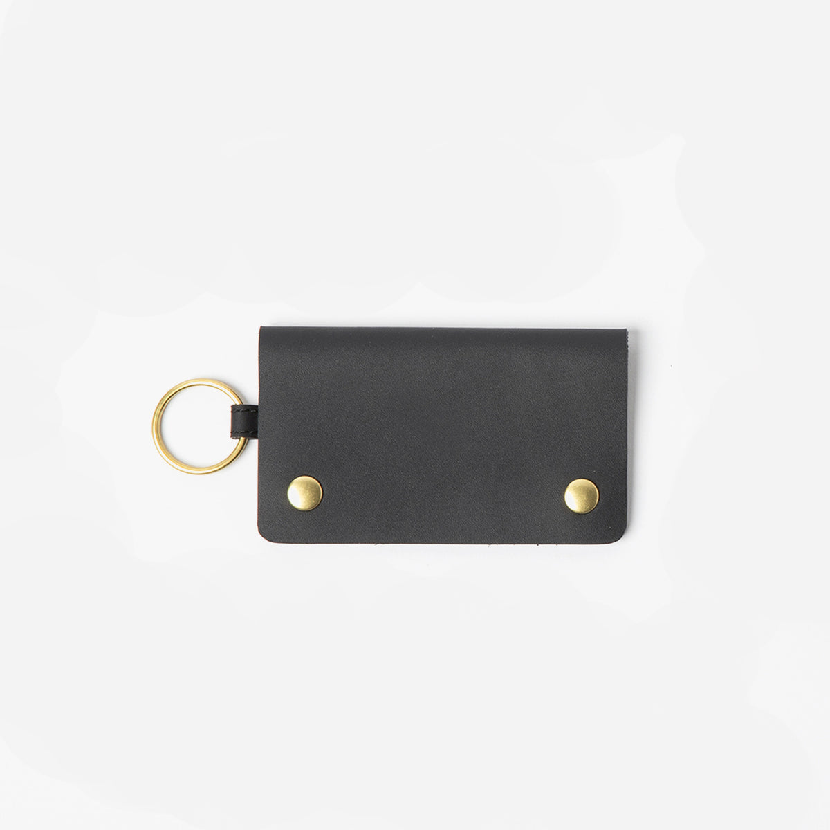 Black leather key fob with gold accents on a white background - Black