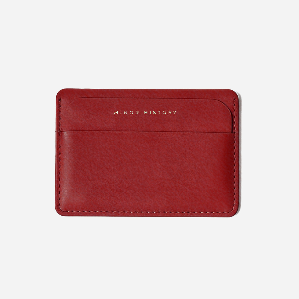 Red leather cardholder with 'Minor History' branding on a light gray background - Cherry Cola