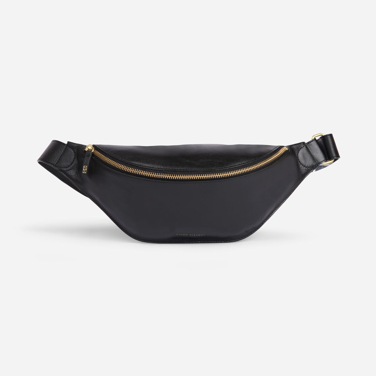 Crosstown sling bag in black full-grain leather, angled side view showing strap design