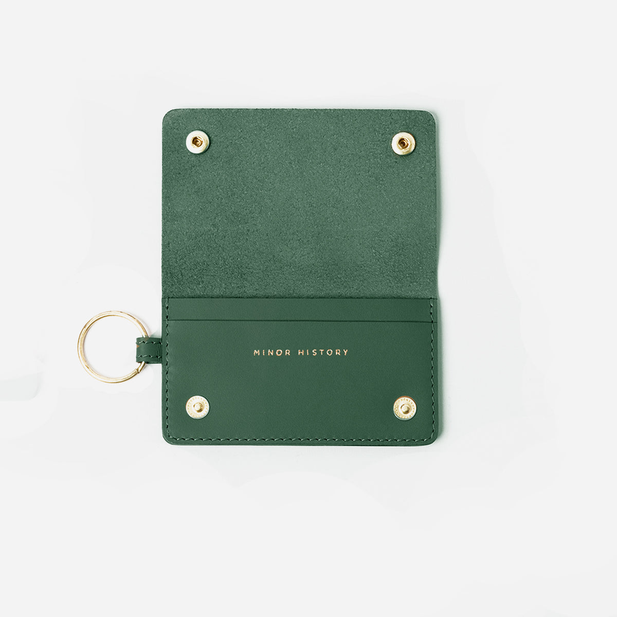 Green leather cardholder with gold accents on a white background - Evergreen

