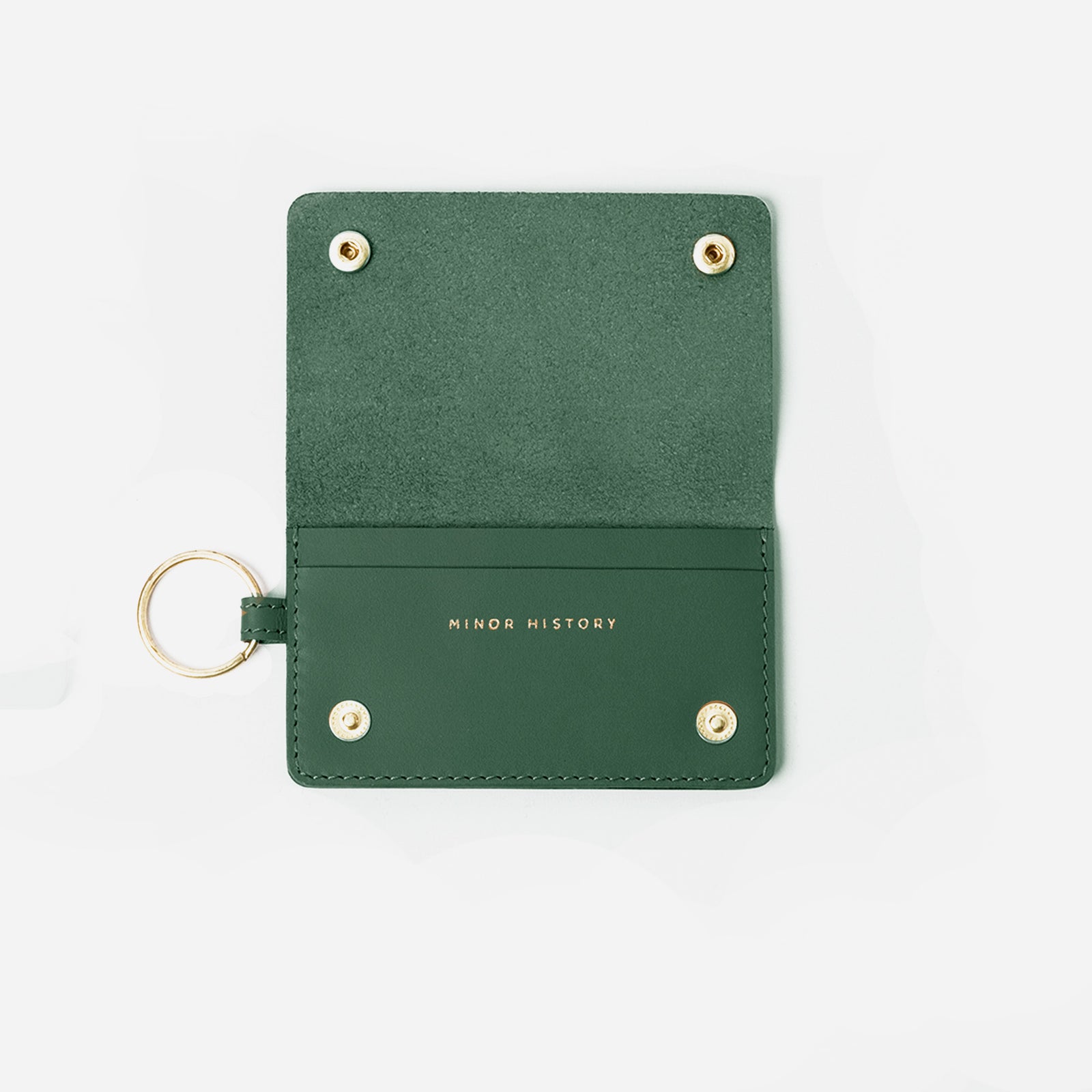 Green leather cardholder with gold accents on a white background - Evergreen
