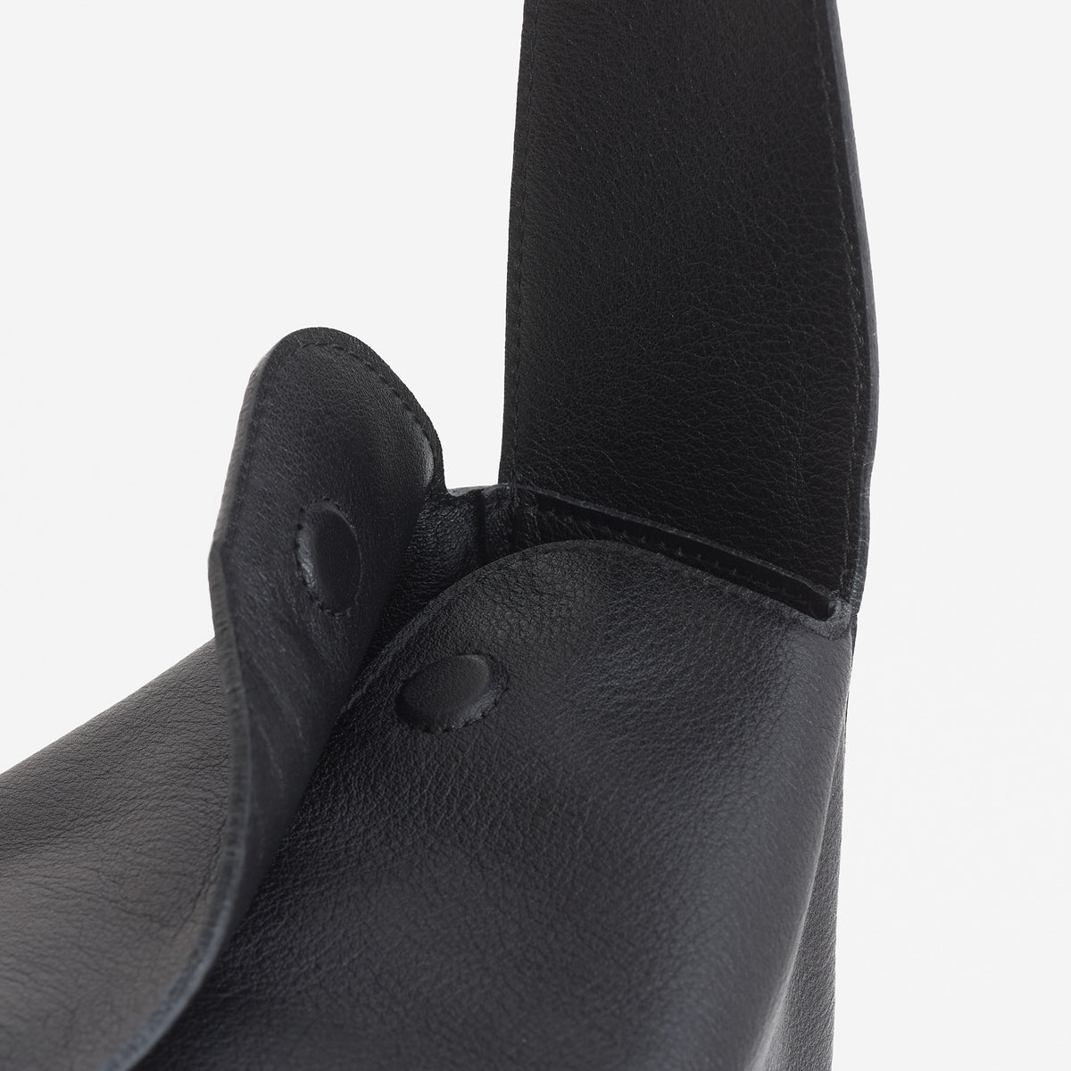 Frame Bag in black full-grain leather, detailed studio shot capturing texture and strap design