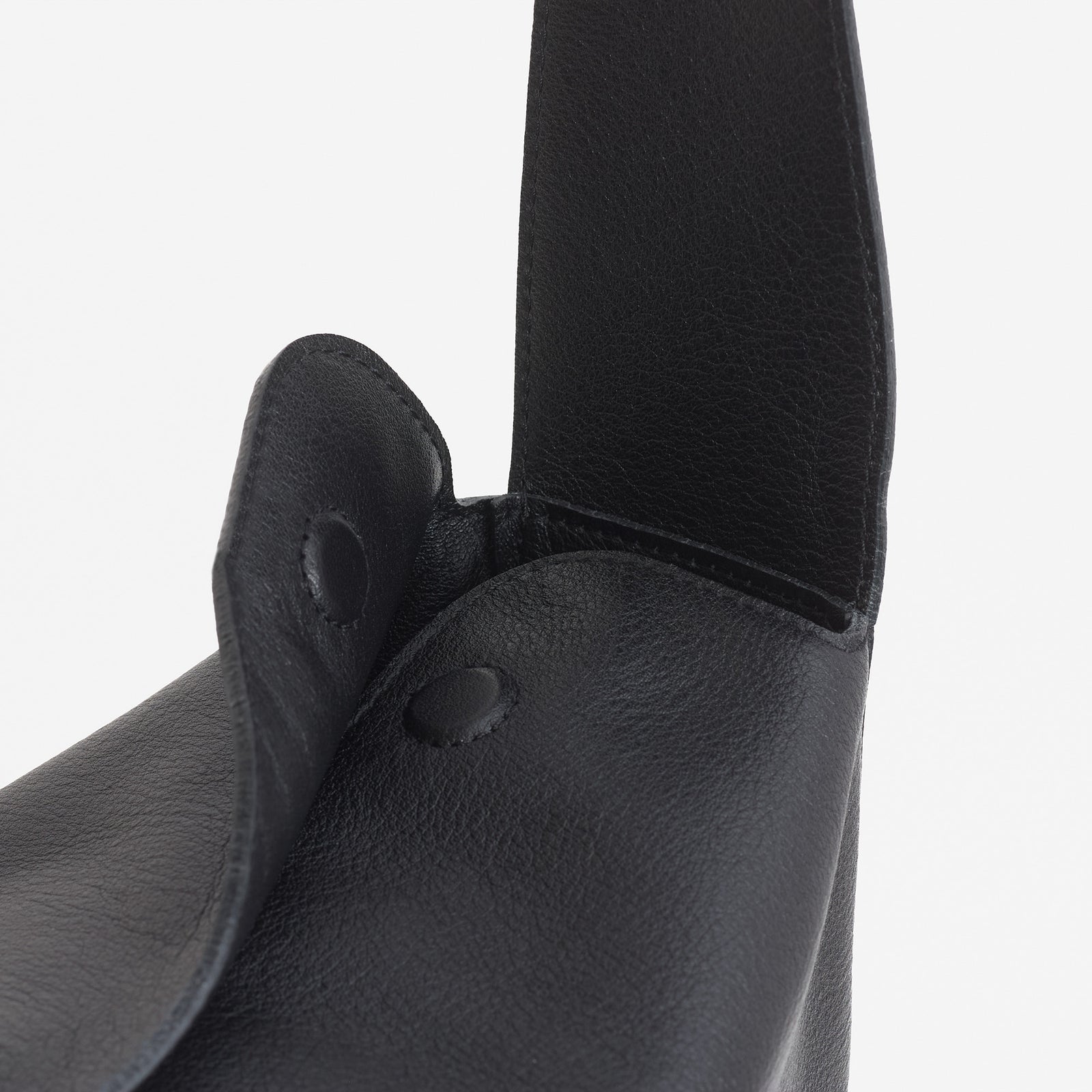 Frame Bag in black full-grain leather, detailed studio shot capturing texture and strap design