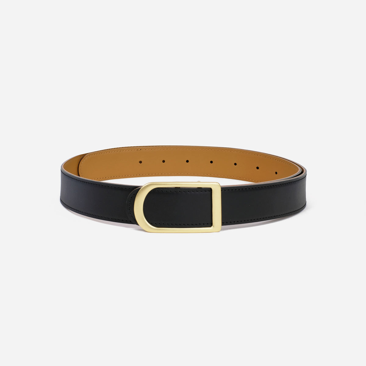 Gemini reversible belt in black and saddle brown full-grain leather with brass buckle, close-up of buckle and leather texture