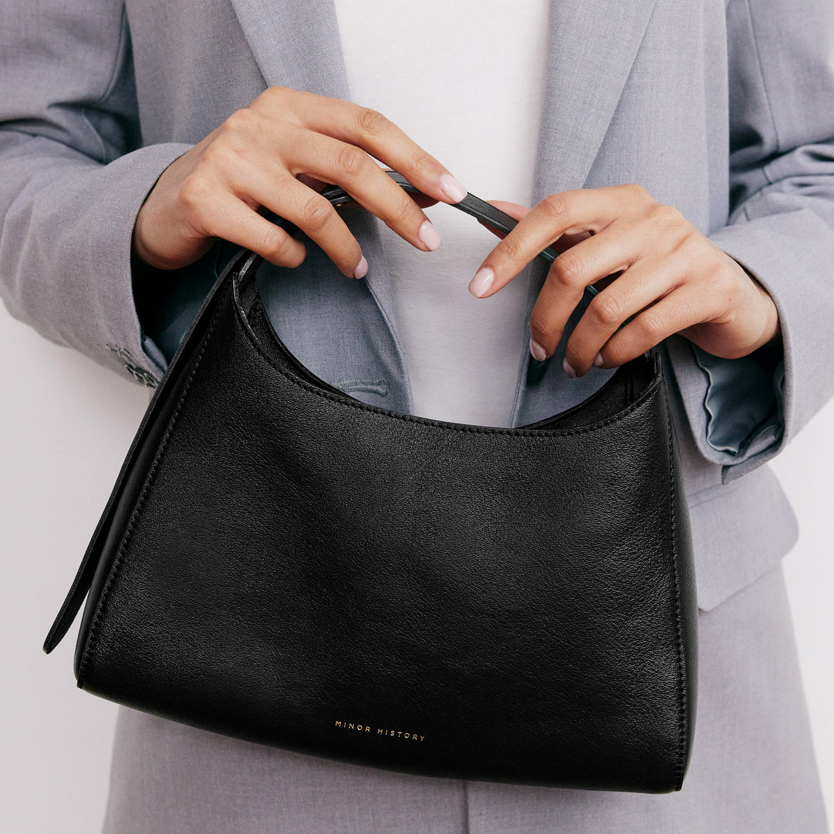 Overtime Tote Bag in black leather shown on minimalist background