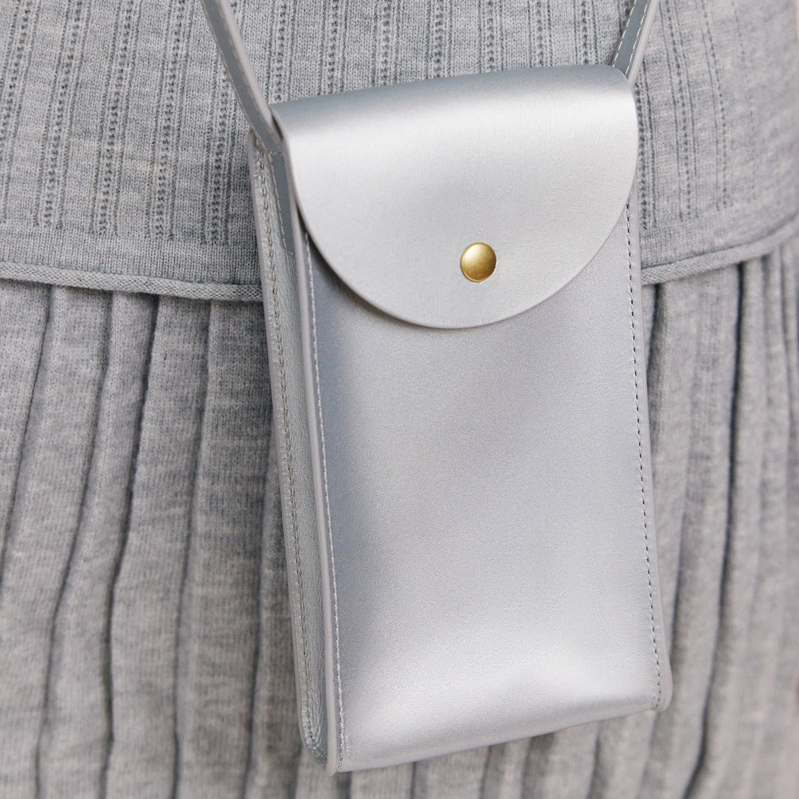 Mini Bandit crossbody bag in sterling silver full-grain leather, cropped view highlighting texture and stitching