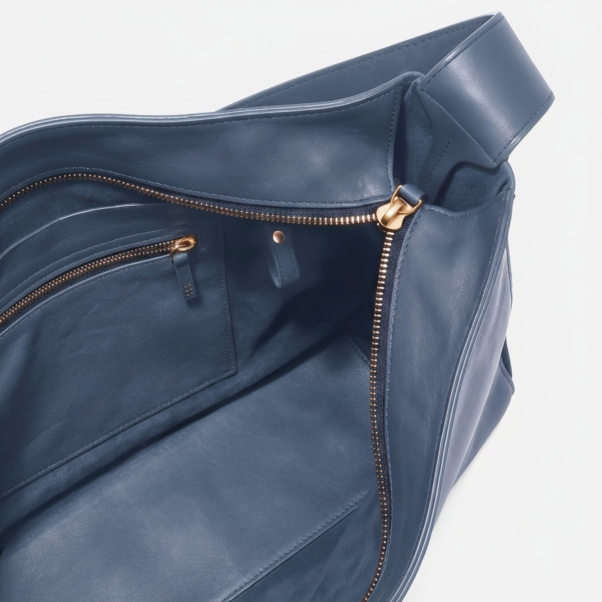 Blue leather bag with gold zipper on a white background - Chambray