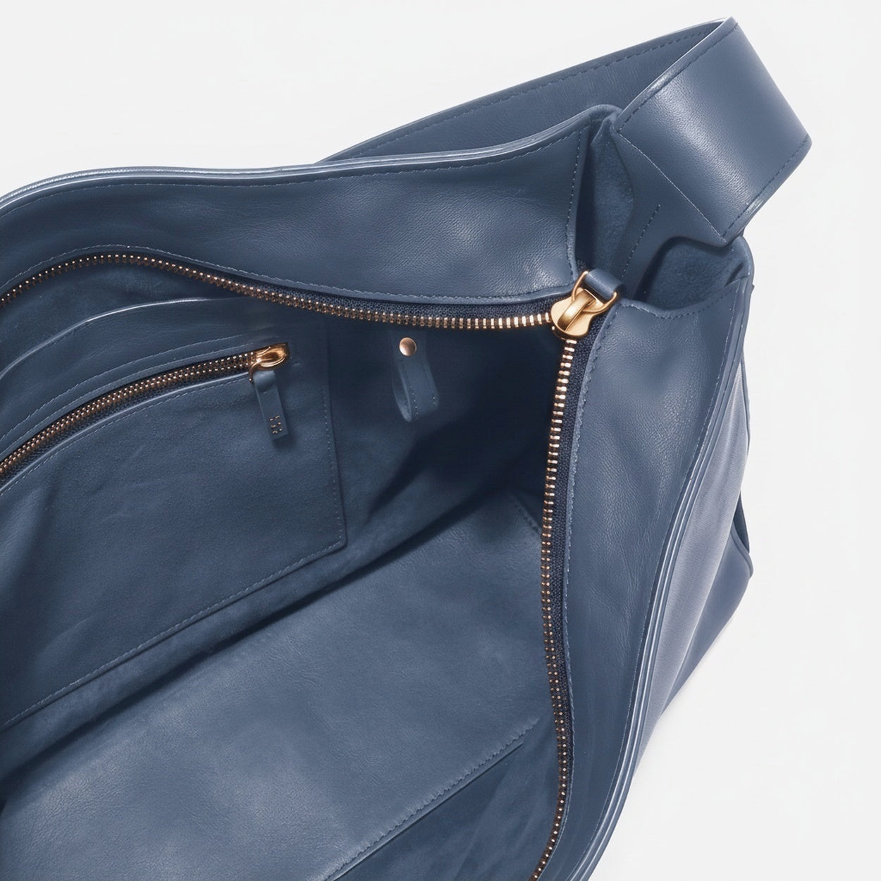 Blue leather bag with gold zipper on a white background - Chambray