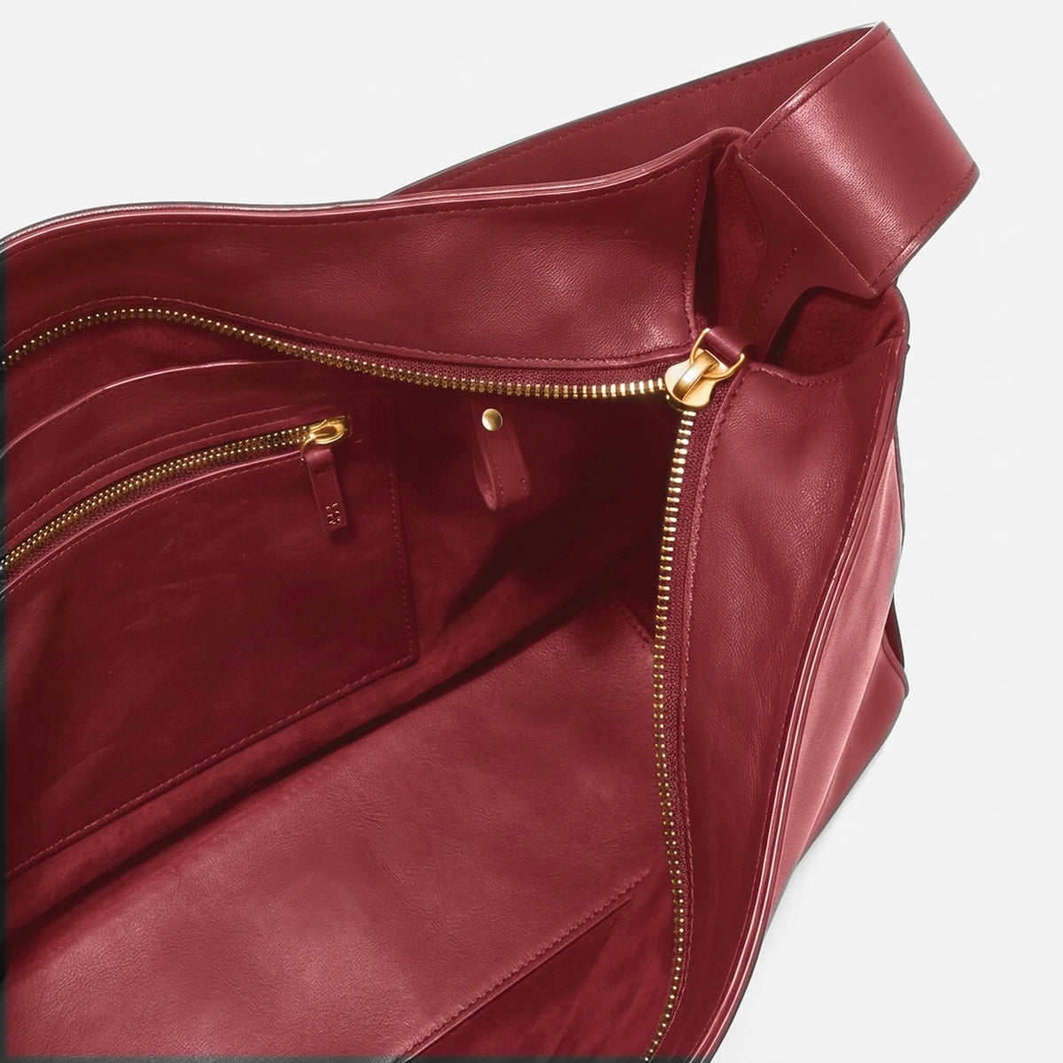 Maroon leather bag with gold zipper on a white background - Cherry Cola
