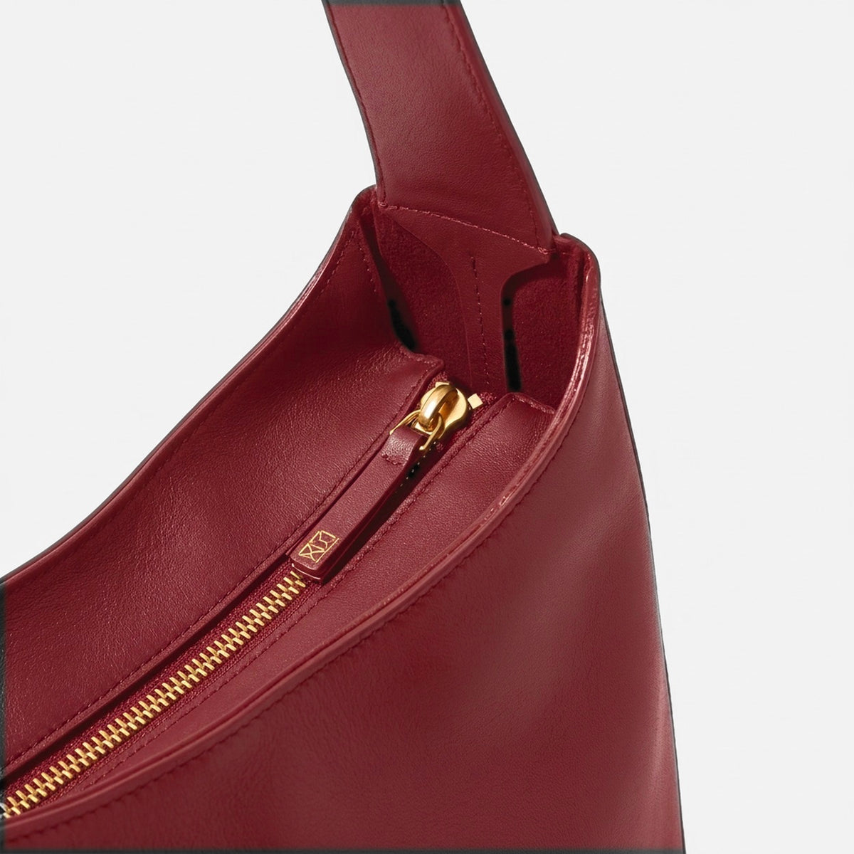 Red handbag with gold zipper on a light gray background -Cherry Cola