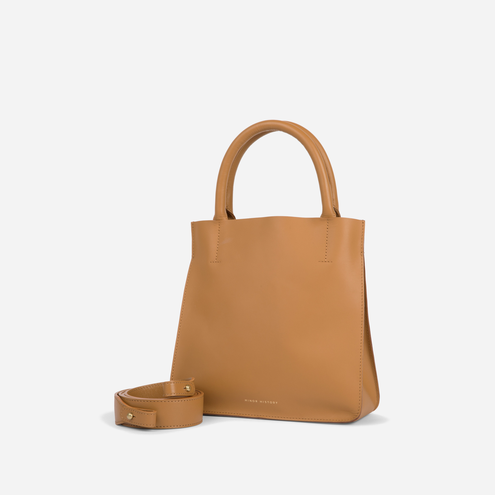 A silver crossbody leather bag with a removable strap and brass hardware, displayed against a plain background. - Sterling