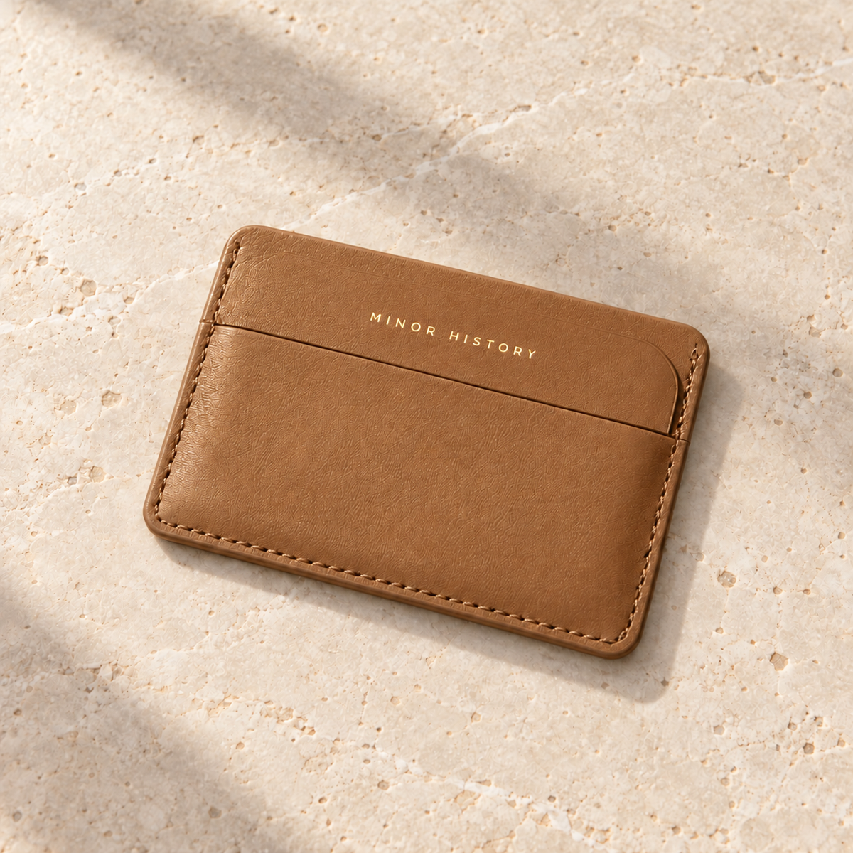 Saddle Midtown card holder resting on a pale stone tabletop - Saddle