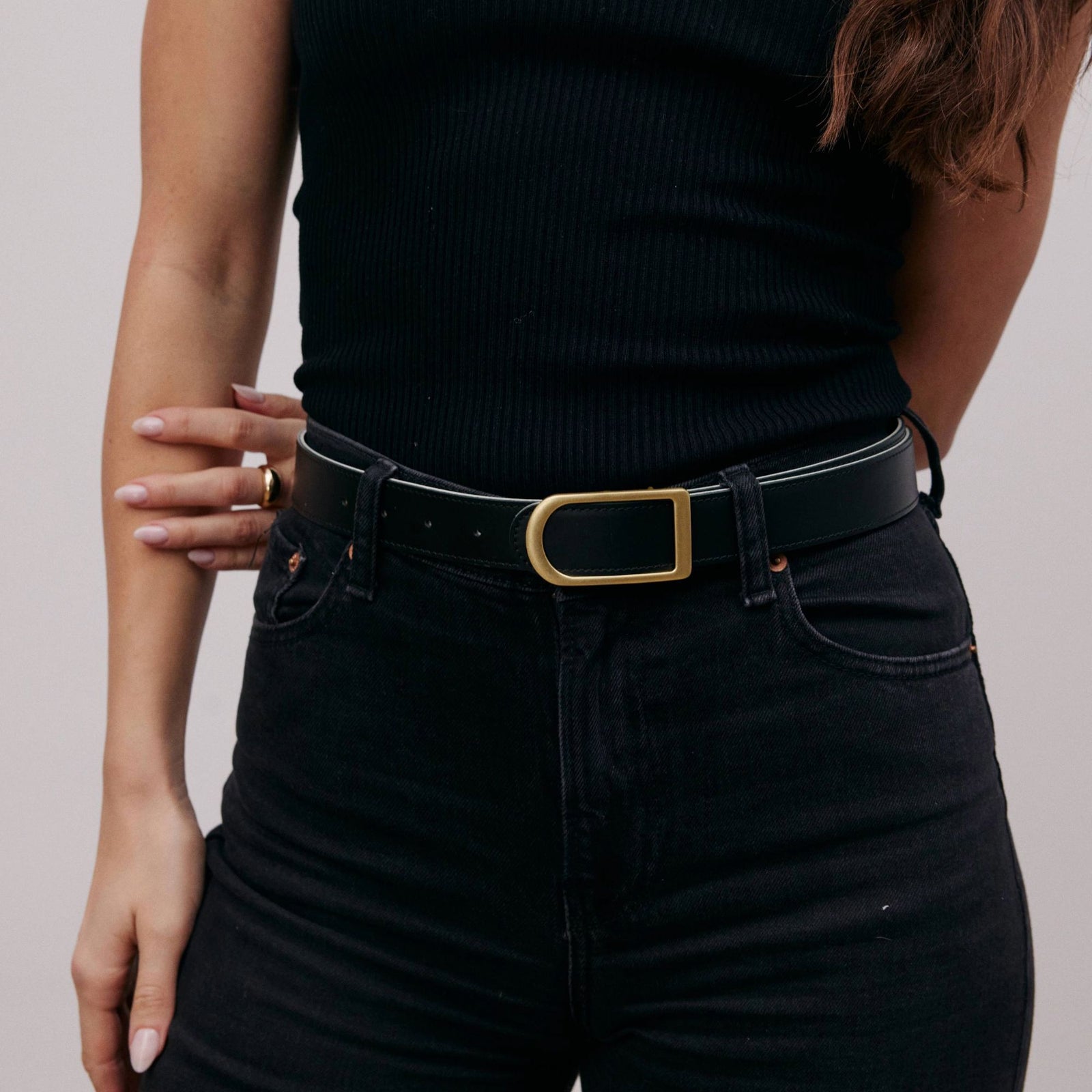 Gemini reversible belt in black full-grain leather with brass buckle, close-up of buckle and leather texture