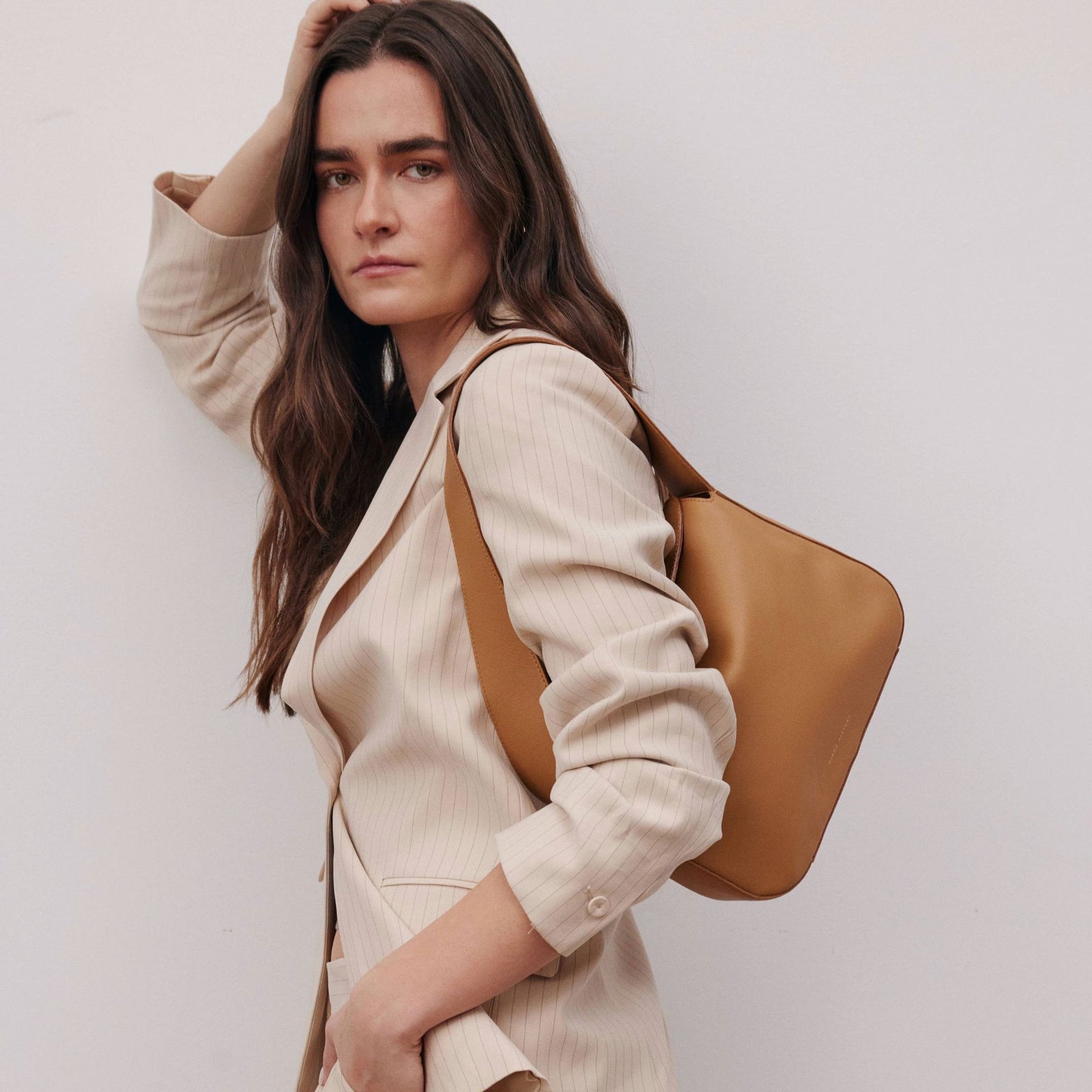 Frame Bag in luxury full-grain leather, minimalist women's handbag in a bright studio setting